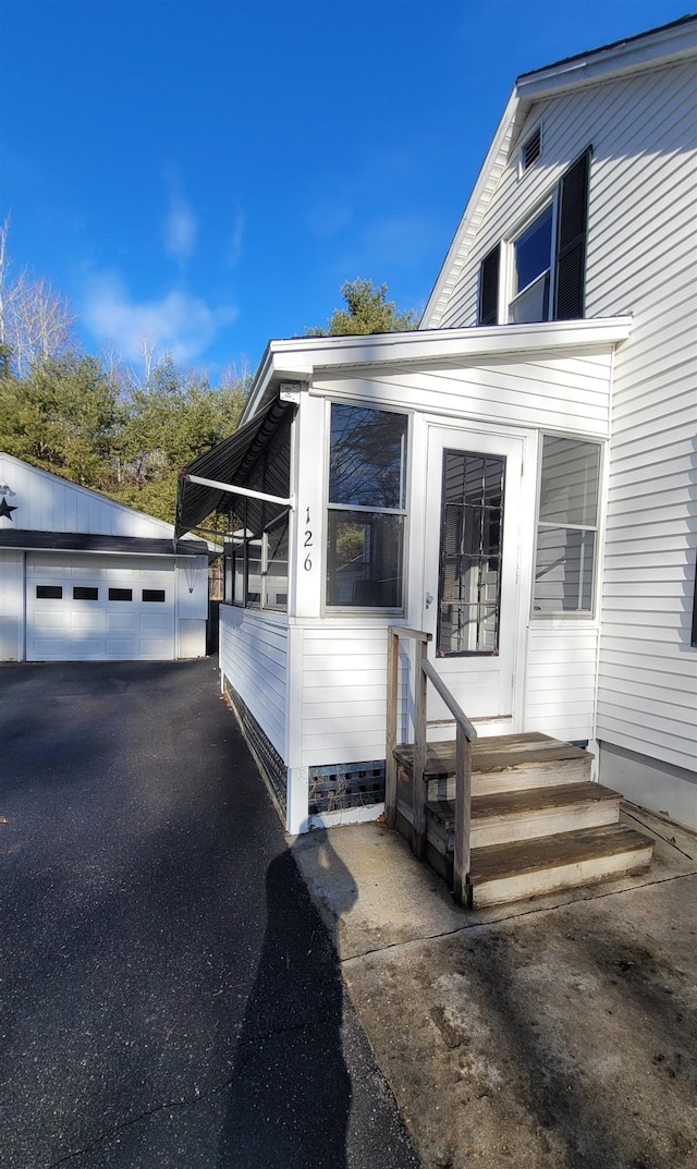 view of property exterior featuring a garage and an outbuilding