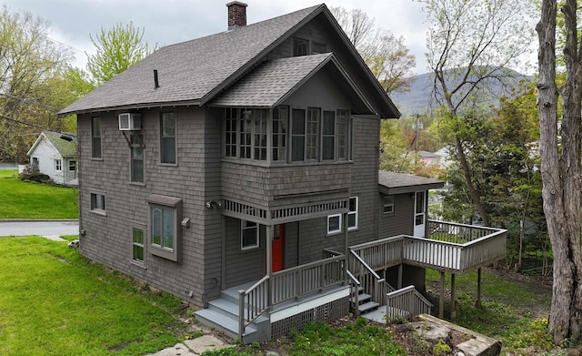 rear view of house featuring a lawn and a deck with mountain view