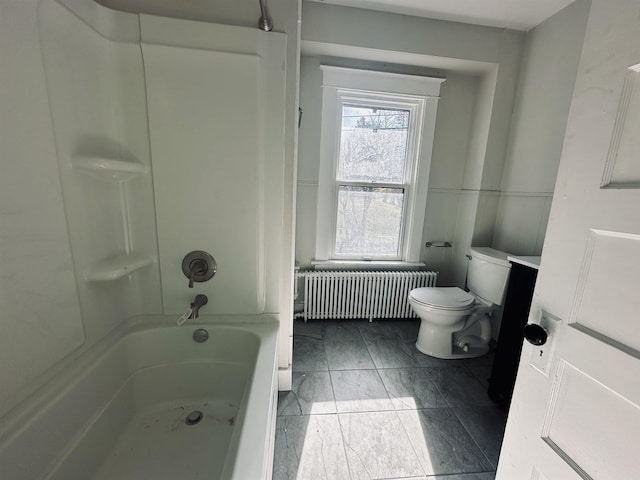 bathroom with washtub / shower combination, toilet, and radiator heating unit