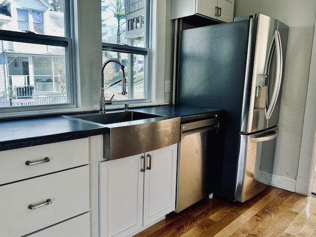 kitchen featuring white cabinets, hardwood / wood-style floors, sink, and stainless steel appliances