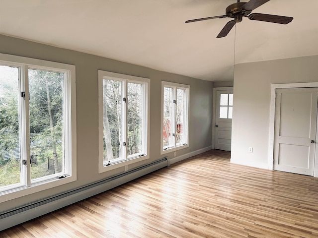 interior space featuring a wealth of natural light, ceiling fan, and a baseboard radiator