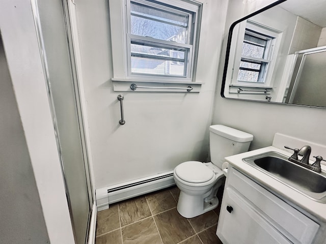 bathroom with vanity, a wealth of natural light, a baseboard heating unit, and a shower with shower door