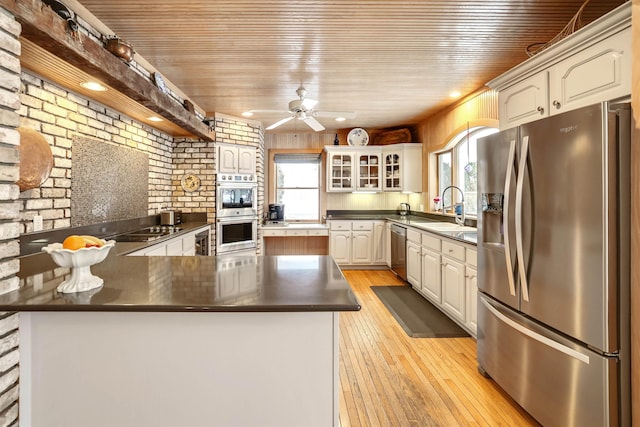 kitchen with sink, wooden ceiling, stainless steel appliances, and brick wall