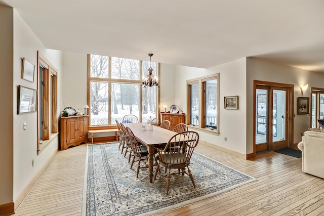 dining space with a chandelier and light hardwood / wood-style floors