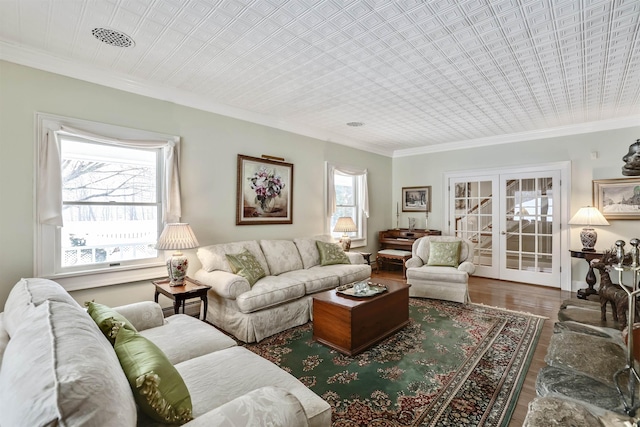 living room with hardwood / wood-style flooring, crown molding, and french doors