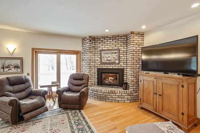 living room with light hardwood / wood-style floors and a fireplace