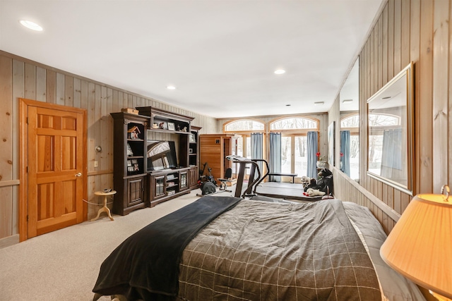 carpeted bedroom with wood walls