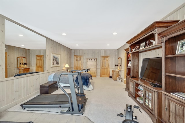 workout room with light colored carpet and wooden walls