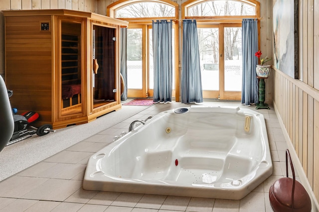 bathroom featuring tile patterned floors and a relaxing tiled tub