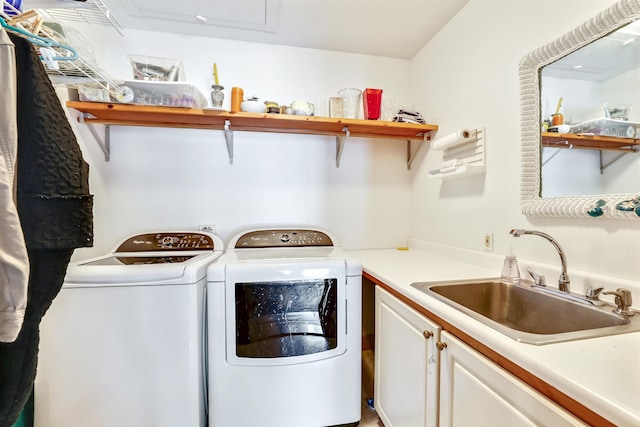 laundry area featuring cabinets, washer and clothes dryer, and sink