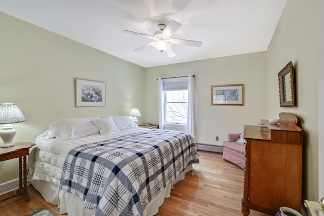 bedroom featuring baseboard heating, ceiling fan, and light hardwood / wood-style flooring