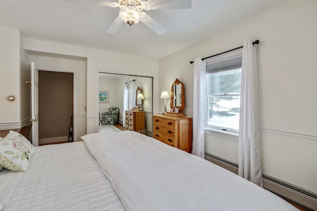 bedroom featuring multiple windows, ceiling fan, and a baseboard heating unit