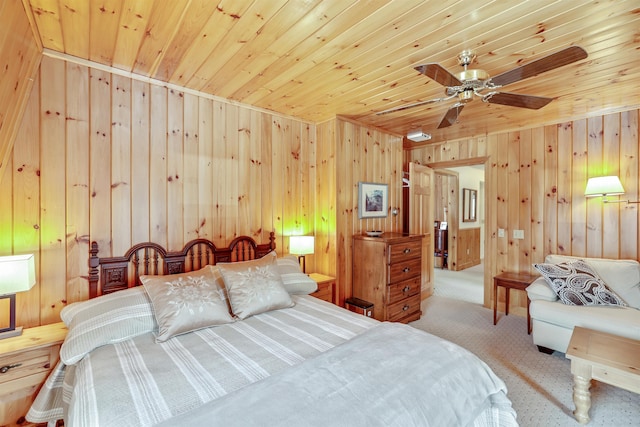 bedroom with ceiling fan, wood walls, light colored carpet, and wood ceiling