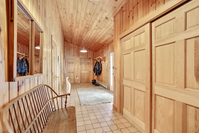 hall featuring wood ceiling, vaulted ceiling, a baseboard heating unit, wooden walls, and light tile patterned floors