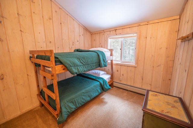 bedroom featuring baseboard heating, wood walls, and dark carpet