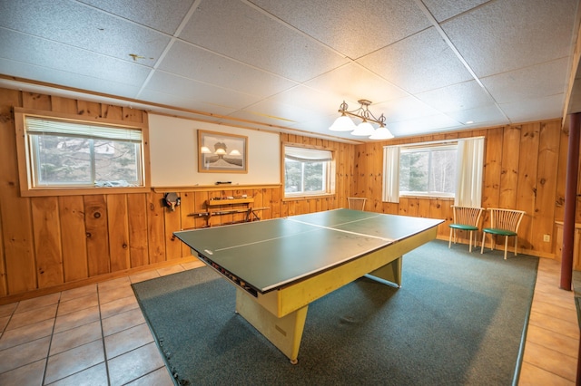 recreation room with tile patterned floors and wooden walls