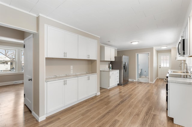 kitchen featuring white cabinetry, stainless steel appliances, and light hardwood / wood-style floors