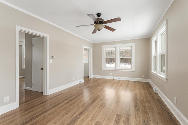 empty room with hardwood / wood-style flooring, ceiling fan, and crown molding