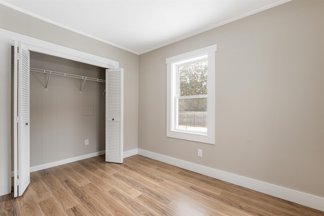 unfurnished bedroom with light hardwood / wood-style flooring, a closet, and crown molding