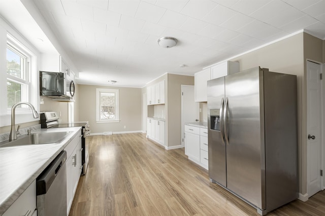 kitchen with crown molding, sink, appliances with stainless steel finishes, light hardwood / wood-style floors, and white cabinetry