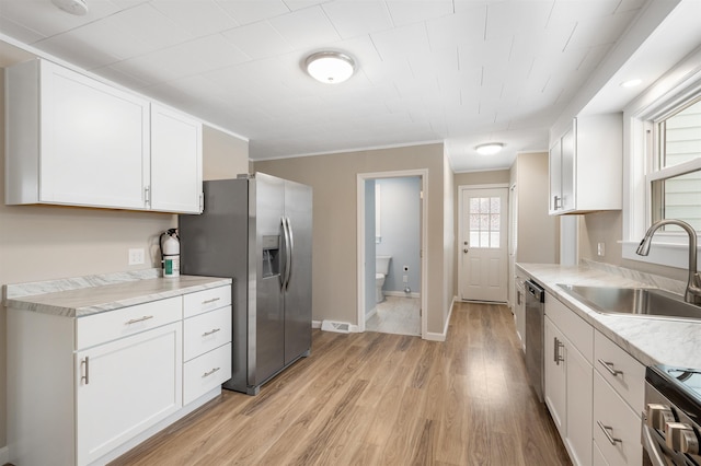 kitchen featuring sink, light hardwood / wood-style flooring, white cabinets, and appliances with stainless steel finishes