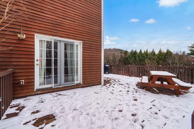 snow covered patio featuring french doors