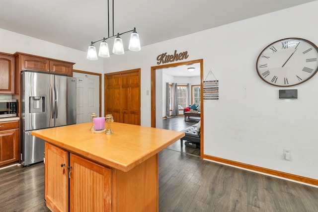 kitchen featuring a kitchen island, pendant lighting, dark hardwood / wood-style floors, and appliances with stainless steel finishes