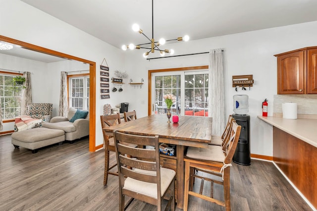 dining space featuring dark wood-type flooring and an inviting chandelier