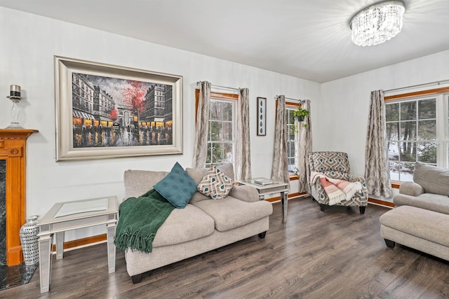 living room with dark wood-type flooring, a healthy amount of sunlight, and a notable chandelier