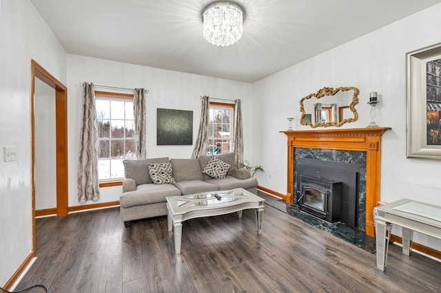 living room with a notable chandelier, a wood stove, and dark wood-type flooring