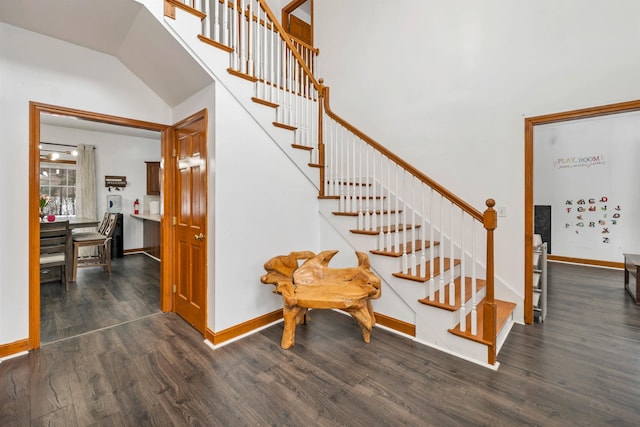 stairway featuring wood-type flooring and a towering ceiling