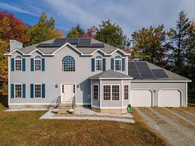 view of front facade featuring solar panels, a garage, and a front lawn