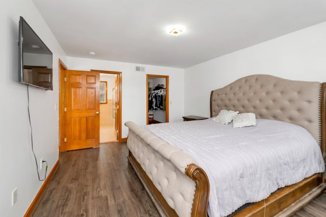 bedroom featuring dark hardwood / wood-style flooring, a spacious closet, and a closet