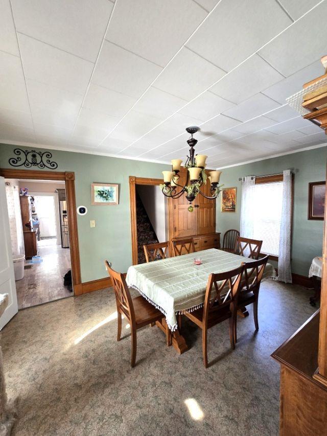 dining area featuring crown molding and a chandelier