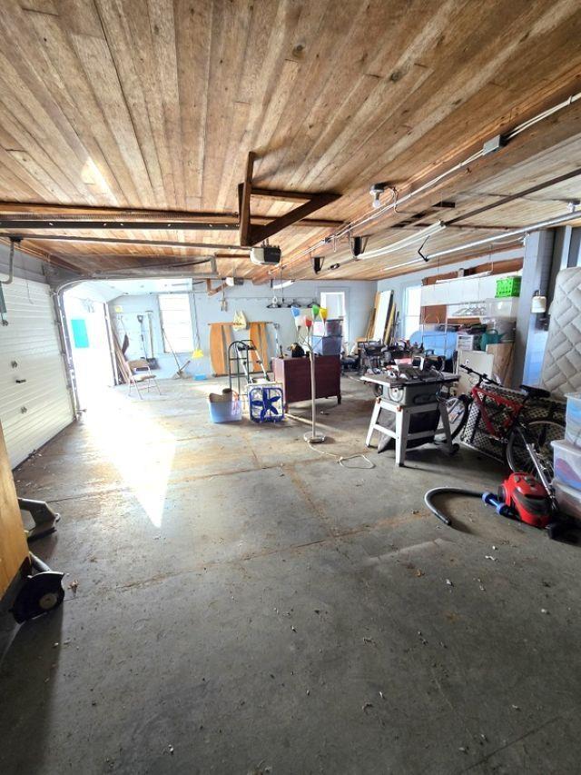 garage featuring a garage door opener and wooden ceiling