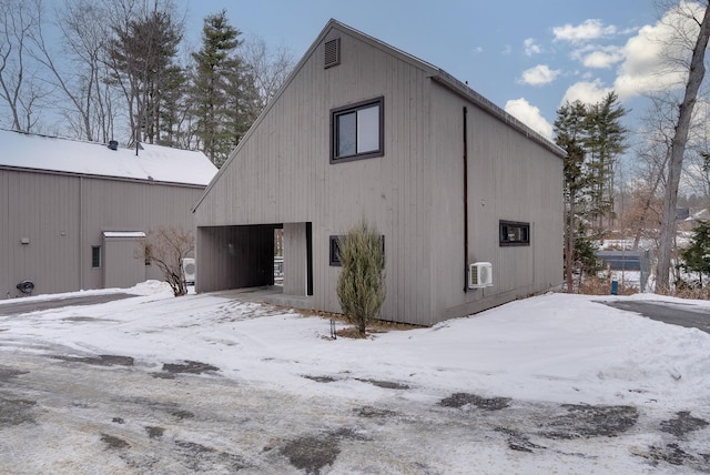 view of snowy exterior with a wall mounted AC