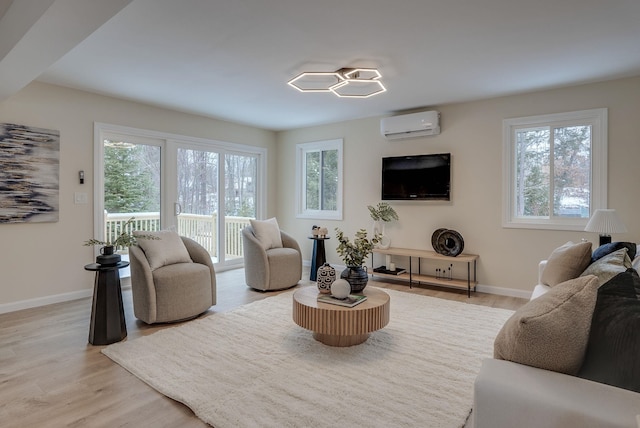 living room featuring plenty of natural light, light hardwood / wood-style flooring, and a wall mounted AC