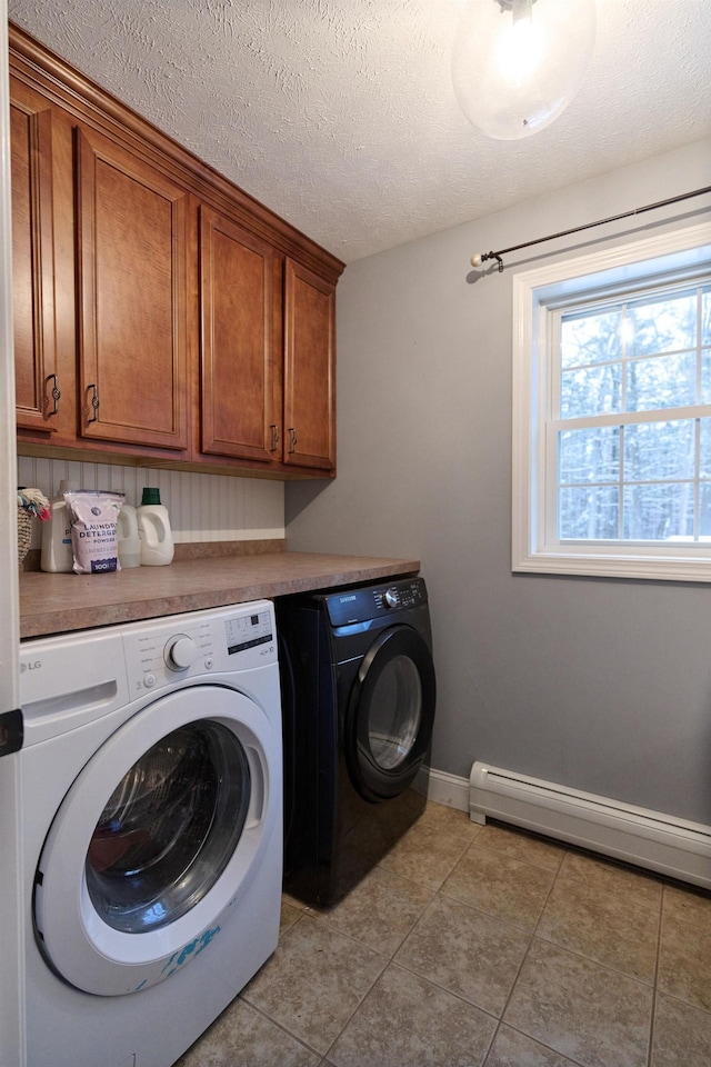 washroom with cabinets, a baseboard heating unit, washing machine and dryer, light tile patterned floors, and a textured ceiling