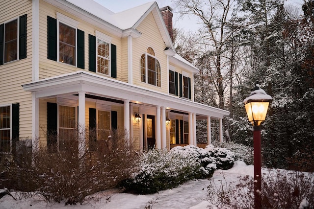 view of snow covered exterior featuring a porch