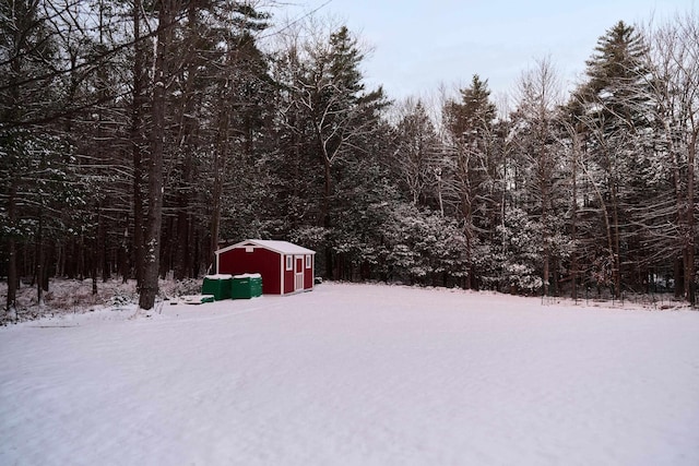 yard layered in snow featuring a shed