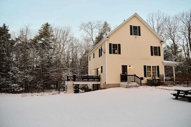 snow covered property with a wooden deck