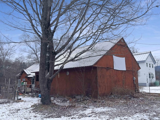 view of snow covered exterior with an outbuilding