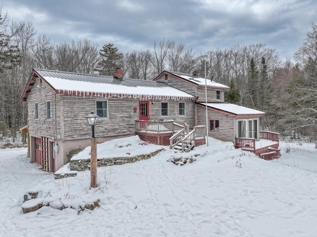 snow covered house with a deck