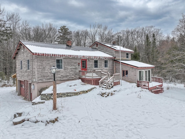 snow covered house with a deck