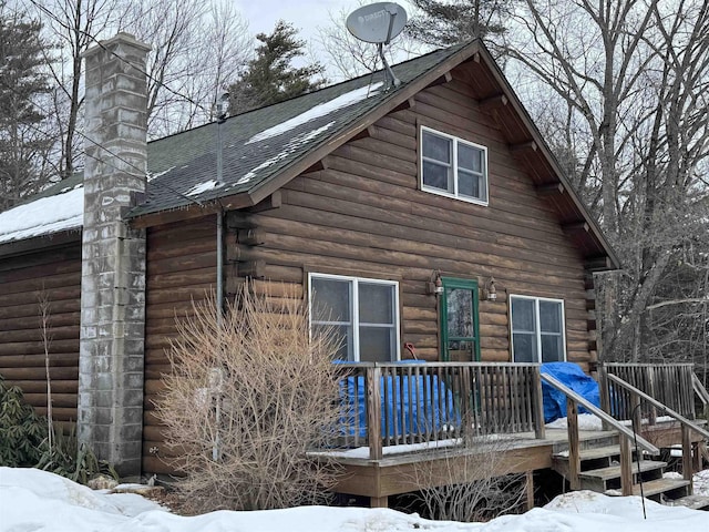 snow covered property with a wooden deck