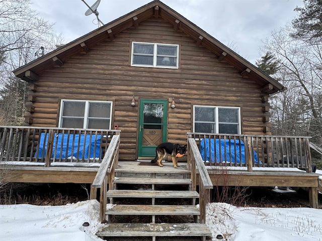 snow covered house with a wooden deck