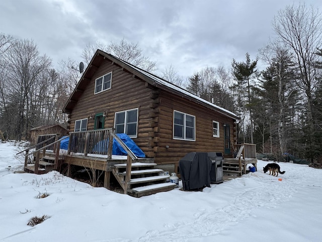 snow covered house featuring a wooden deck