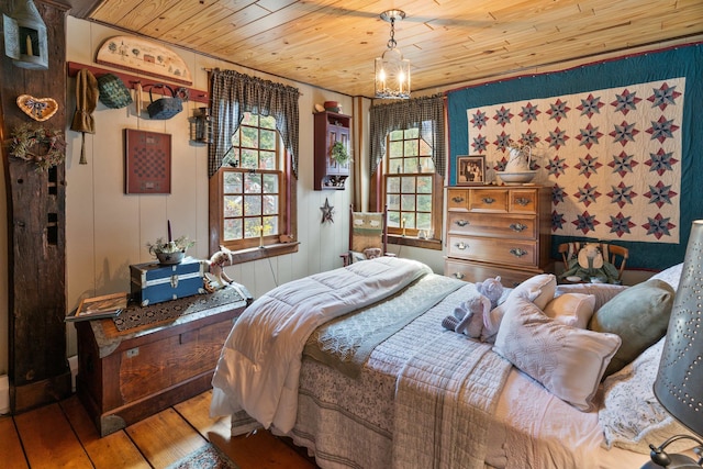 bedroom with wooden ceiling, a notable chandelier, and hardwood / wood-style flooring