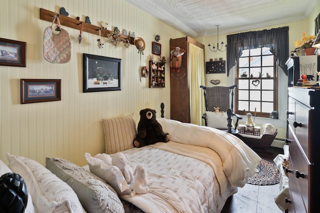 bedroom featuring a notable chandelier, wood walls, and ornamental molding