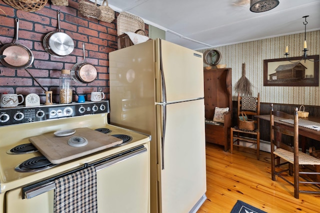 kitchen with range with electric cooktop, light hardwood / wood-style flooring, white fridge, and brick wall